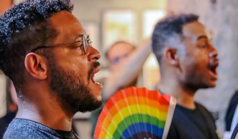 Cantores do CHGSP de perfil ao lado de um leque colorido